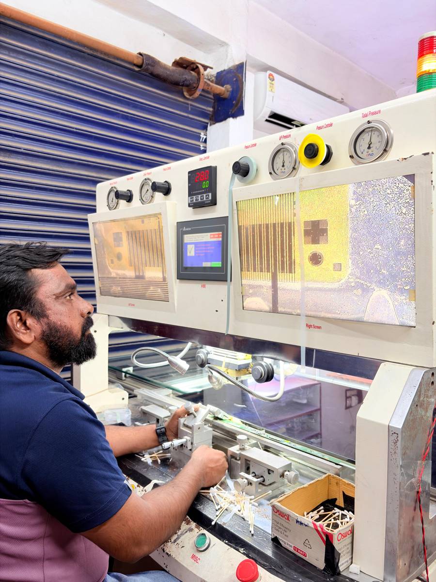 Technician operating the COF bonding machine with pressure gauges, temperature controller and two magnified screens