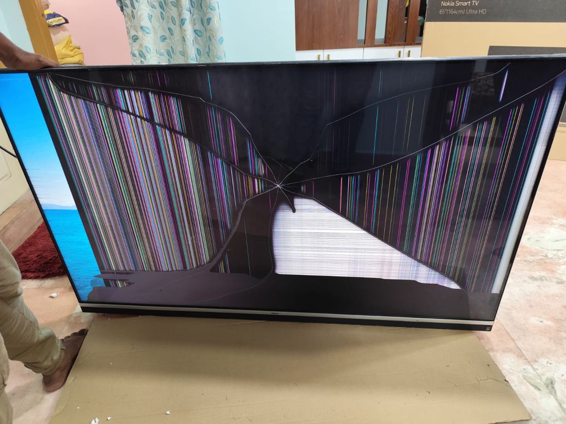 Large TV with a cracked panel and coloured lines